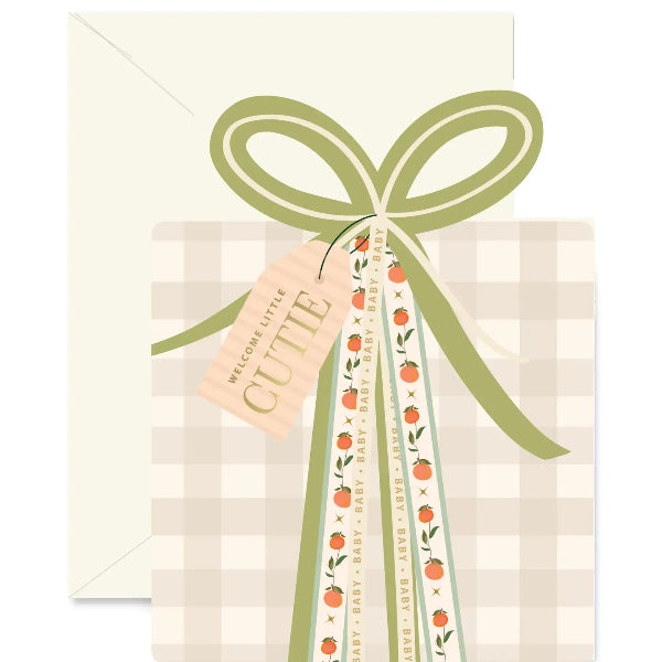 Gift card with green ribbon and baby-themed tag on a checkered background