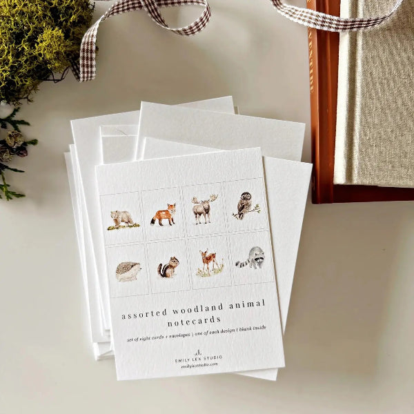 Set of woodland animal notecards on a light surface with decorative elements.