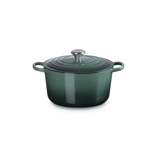 Green enameled cast iron Dutch oven with lid on a white background