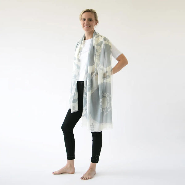 Woman wearing a long, light-colored scarf on a white background