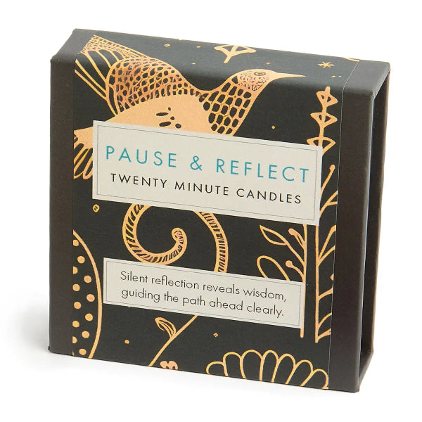 Box of 'Pause & Reflect' twenty-minute candles with decorative gold designs on a black background.