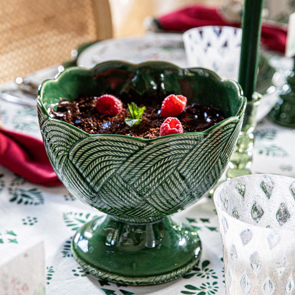 Green ceramic dish with dessert on a patterned tablecloth