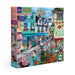 Jigsaw puzzle box featuring a colorful village scene with shops and people.