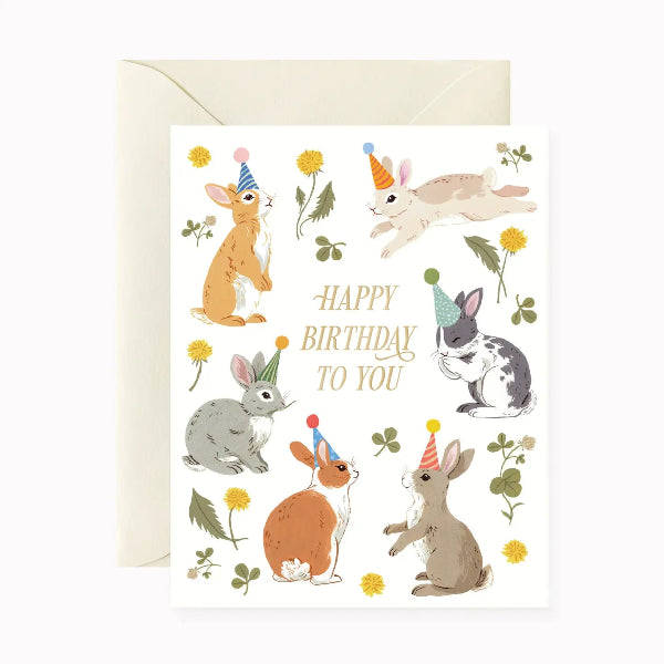 Birthday card with illustrations of rabbits wearing party hats on a white background.