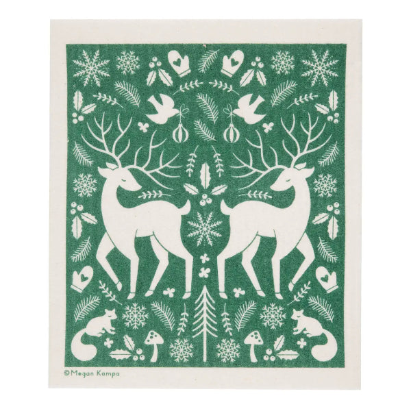 A swedish dishcloth featuring a festive winter design in green and off-white. The pattern includes two large deer facing each other, snowflakes, birds, pine branches, mushrooms, a small fox, and a central evergreen tree.
