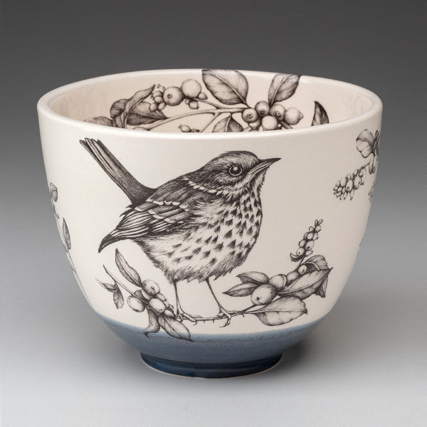 Ceramic bowl with bird and floral design on a gray background