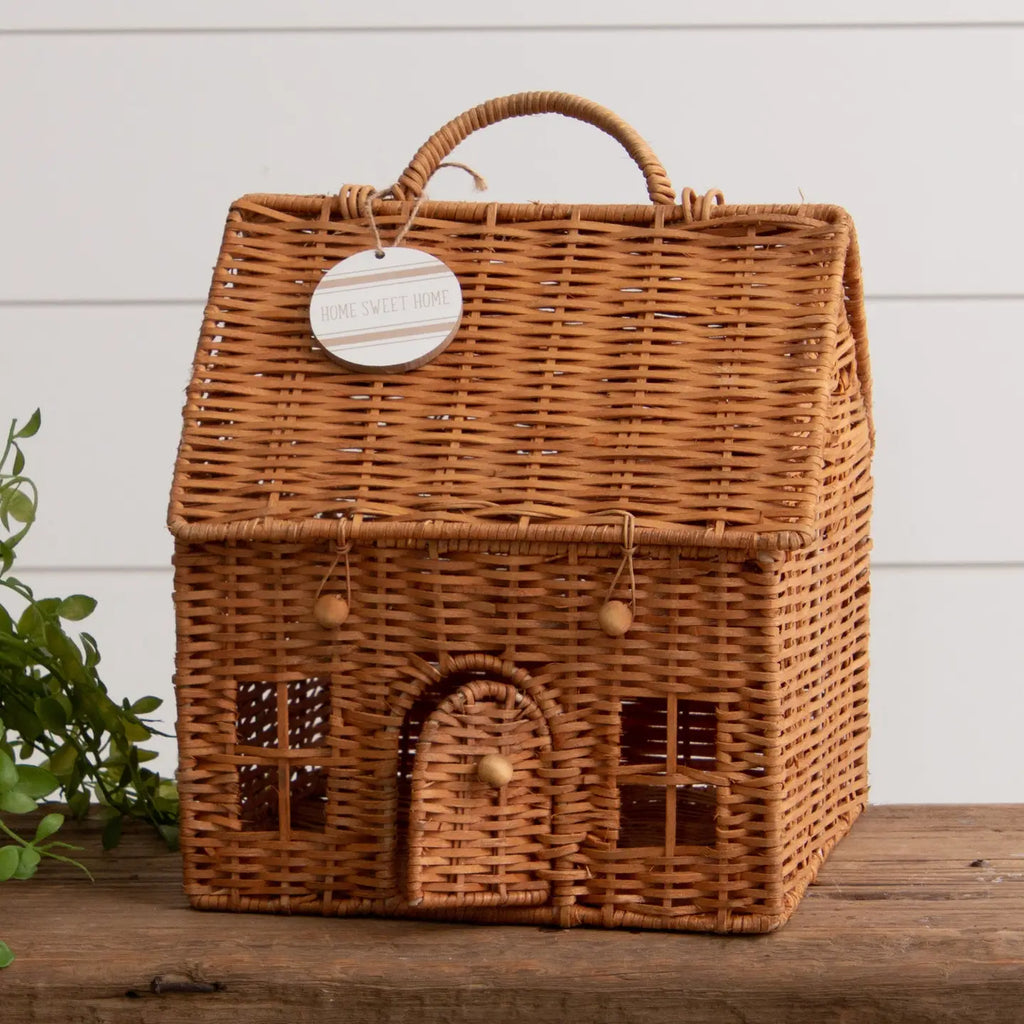 Wicker house-shaped basket with a tag on a wooden surface