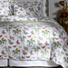Butterfly and floral patterned bedding set on a bed with a nightstand in the background.