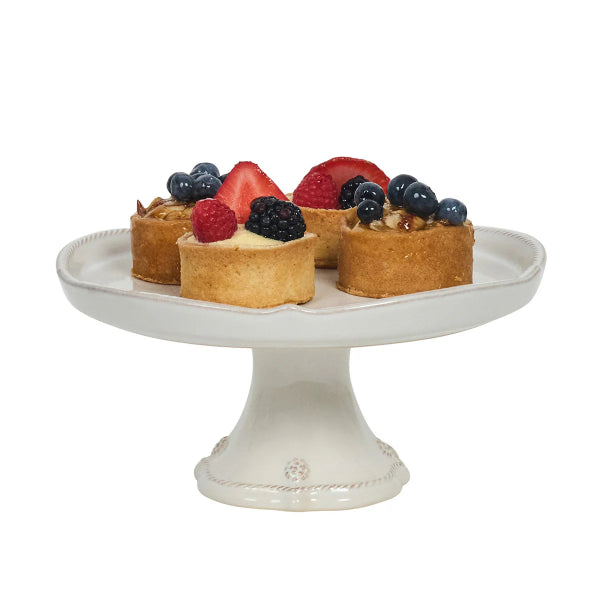 Small fruit tarts on a decorative white cake stand with a white background