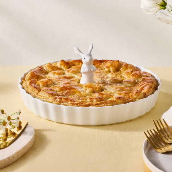 Pie with a rabbit-shaped pie bird on a yellow table