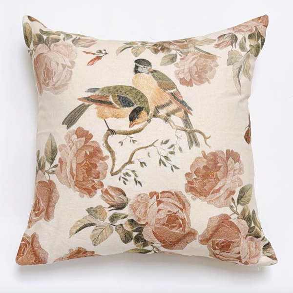 Decorative pillow with floral and bird pattern on a white background