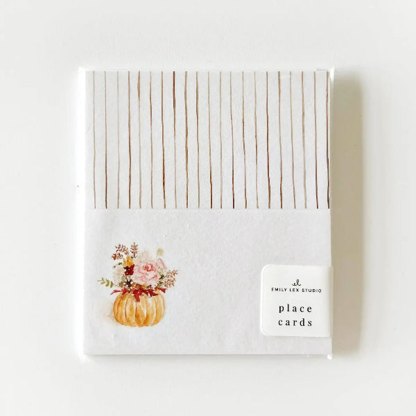 A square pack of Emily Lee Studio place cards featuring a white background with thin vertical brown stripes on the top half and a watercolor illustration of a small orange pumpkin with pink flowers on the bottom half. A small white label on the right reads 'EMILY LEE STUDIO place cards'.