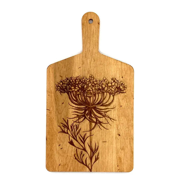 Wooden cutting board with laser-cut floral design on a white background