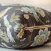 Pillow with floral and bird pattern on a gray background