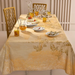Dining table set with a floral tablecloth, glasses, and plates.