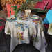 Outdoor table setting with a floral tablecloth and colorful plates.